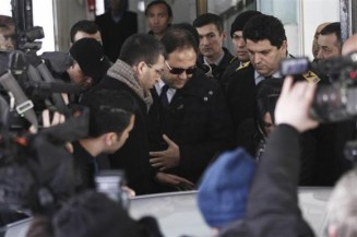 Baris Guler, son of Turkey's Interior Minister Muammer Guler, is escorted by plainclothes police officers as he leaves following a medical control in Istanbul