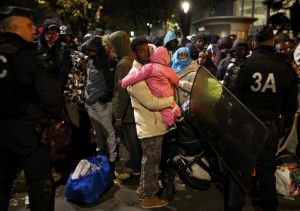 Migrants wait before entering buses as part of their transfer by French authorities to reception centres across the country during the dismantlement of makeshift camps in a street near Stalingrad metro station in Paris, France, November 4, 2016. REUTERS/Benoit Tessier